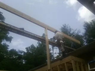 Carpenter setting a ridge beam over a new addition frame — Ice Dam Removal by Roofing Brothers in Avera