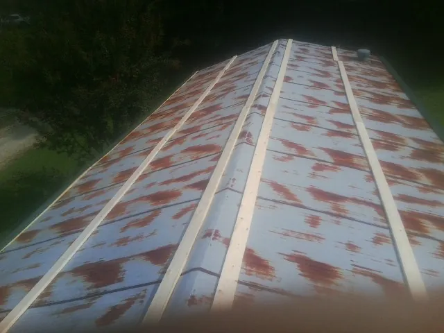 Rusted metal roof panels with new wood purlins before replacement — Storm Damage Roof Repair in Avera by Roofing Brothers