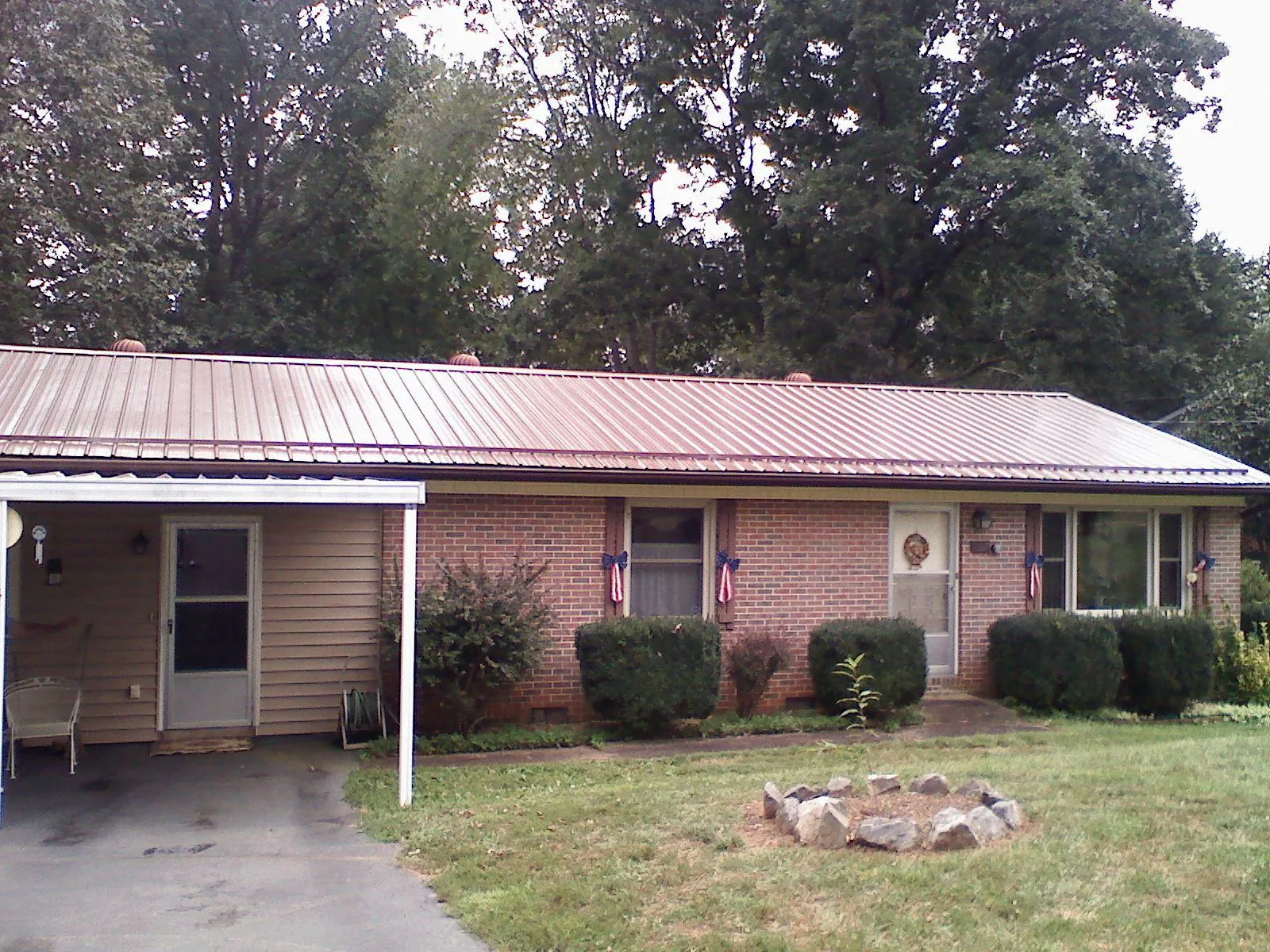 Bronze metal roof and carport on a brick ranch home — Roof Repair work by our crew in Avera